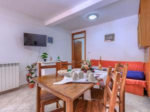 a dining room with a table and a couch at Apartment Vinka by Interhome in Žminj