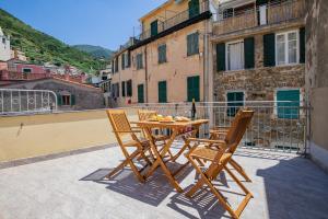 a wooden table and chairs sitting on a balcony at Pasini Luxury room,cozy winemakers retreat in Riomaggiore