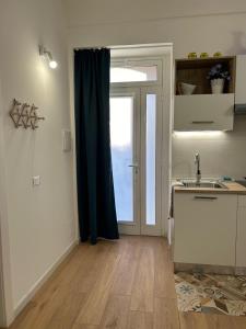 cocina con fregadero y puerta con ventana en Dimora Claramare, en Marzamemi