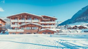 a large wooden building with snow on the ground at La Clef des Champs in Morzine