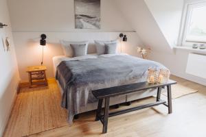 ein Schlafzimmer mit einem großen Bett und einem Tisch in der Unterkunft Seetiid in Westerland