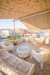 a patio with chairs and a table on a balcony at Ten Suns Downtown B by 8essentially in Lixouri