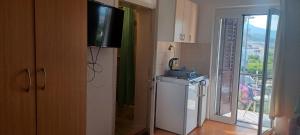 eine Küche mit einem Waschbecken, einem TV und einem Fenster in der Unterkunft Studio apartman za 2 uz more in Makarska
