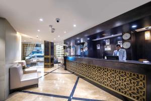 Lotus Grand Hotel في دبي: رجلان يقفان في حانة في فندق +37 صورة