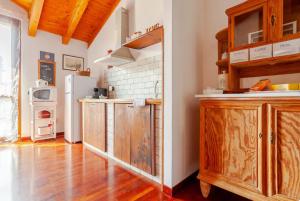 a kitchen with wooden cabinets and a refrigerator at Il nido della cicogna in Certosa di Pavia
