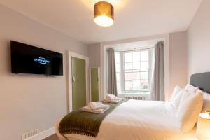Un dormitorio con una cama con un televisor en la pared. en Old Town Trinity Apt No 3 By Adliv, en Margate