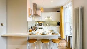 una cocina con una barra con tres taburetes en Old Town Trinity Apt No 3 By Adliv, en Margate