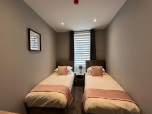 科克茅斯The Globe Apartments的有窗户的房间里有两张床