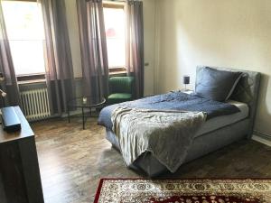 a bedroom with a bed and a table and windows at Time-Out Westerbauer TE13 in Hagen