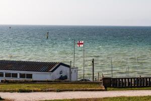 a canadian flag flying in front of the ocean at Seaview Apt Turner Contemporary, Margate By Adliv in Margate