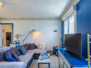 a living room with a couch and a flat screen tv at Holiday Home la maison du bonheur by Interhome in Primelin