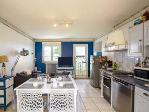 a kitchen and living room with blue walls at Holiday Home la maison du bonheur by Interhome in Primelin
