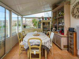 a kitchen with a table and chairs and a clock at Holiday Home la maison du bonheur by Interhome in Primelin