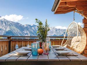 a table on a deck with a view of mountains at Chalet Le Loup- le Renard et la Belette by Interhome in Nendaz