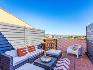 a patio with a couch and chairs on a balcony at Apartment Les Marines-14 by Interhome in La Foux