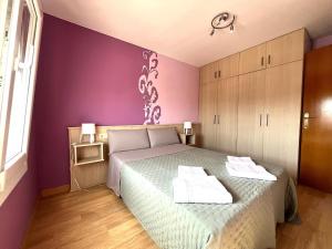 a bedroom with a bed and a purple wall at Estupendo Apartamento in Miami Platja