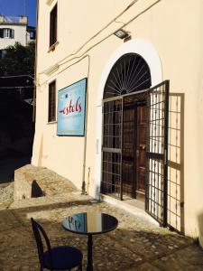 uma mesa e cadeiras em frente a um edifício em Hostels Euro Mediterraneo em Rossano