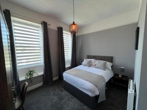科克茅斯The Globe Apartments的带一张床和两扇窗户的卧室
