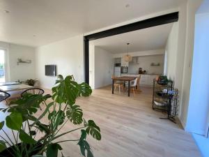 a living room with a table and a dining room at En vacances Simone ! in Plurien