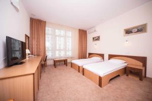 a hospital room with two beds and a television at Optima Odesa in Odesa