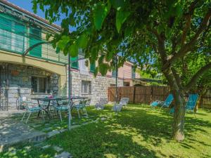 Un patio con una mesa y sillas debajo de un árbol. en Holiday Home Casa dei Gelsi by Interhome, en Castiglione Chiavarese