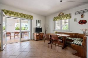 Una sala de estar con una mesa y sillas y un televisor. en Villa Sunset Sea, en Augusta