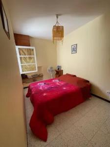 una camera da letto con un letto con una coperta rossa di Maison charmante à Montblanc avec terrasse a Montblanc