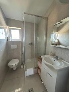a bathroom with a shower and a toilet and a sink at Apartman Lorna in Turanj +44 photos