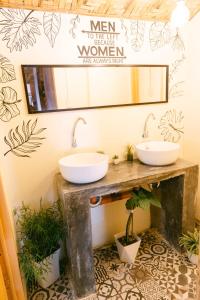 two sinks in a bathroom with a mirror and plants at katana siargao in Catagnan +7 photos