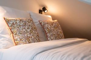 - un lit avec des draps et des oreillers blancs dans l'établissement Functional & equipped duplex studio, Old Lille, à Lille