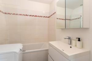 une salle de bain blanche avec un lavabo et une baignoire dans l'établissement Functional & equipped duplex studio, Old Lille, à Lille