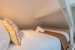 un lit avec des oreillers dessus dans une chambre dans l'établissement Functional & equipped duplex studio, Old Lille, à Lille