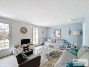 un soggiorno con un divano e una TV di La Brise Bleue - Maison avec Jardin, Garage, 400m Plage a Bray-Dunes