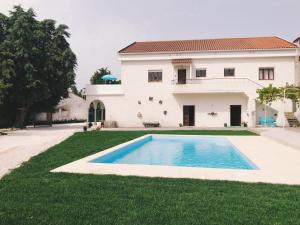 a house with a swimming pool in front of a yard at Meio Country House in Alcanede