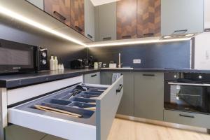 a kitchen with a stove and a microwave at Modern 1-Bedroom Apartment with Free Parking in Plovdiv