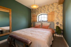 a bedroom with a large bed with a large window at B&B Mijllerzicht in Lunteren
