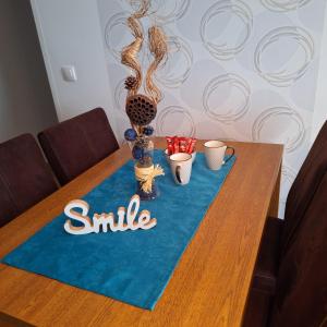 ein Tisch mit einem Smiley-Schild und zwei Tassen darauf in der Unterkunft Kraljevski kutak Kraljevi čardaci in Kopaonik