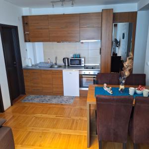 a kitchen with a dining table and a kitchen with wooden cabinets at Kraljevski kutak Kraljevi čardaci in Kopaonik +6 photos