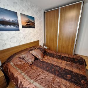 a bed in a bedroom with two pictures on the wall at Kraljevski kutak Kraljevi čardaci in Kopaonik