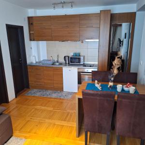 a kitchen with a dining room table and a kitchen with a counter at Kraljevski kutak Kraljevi čardaci in Kopaonik