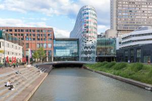 Un puente sobre un río en una ciudad con edificios. en Crowne Plaza Utrecht - Central Station by IHG, en Utrecht