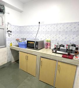 a kitchen with a counter with a microwave on it at Ga-Ki-Khim Homestay in Gangtok