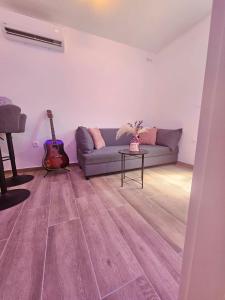 a living room with a couch and a guitar at Rita Apartments in Makarska