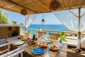 a dining table with a view of the ocean at Korali Sea House in Archangelos