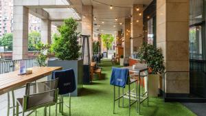 a room with chairs and plants in a building at Holiday Inn Manchester - City Centre, an IHG Hotel in Manchester