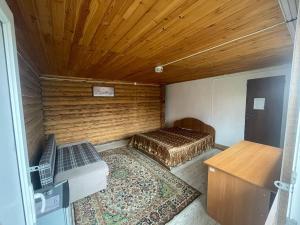 a small room with a bed and a wooden ceiling at Иртыш in Borovoye