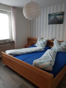 a bedroom with two twin beds with blue sheets at Ferienhaus Leuchtturm in Geestland