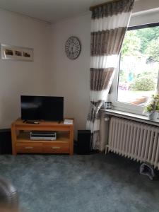 a living room with a television and a window at Ferienhaus Leuchtturm in Geestland +15 photos
