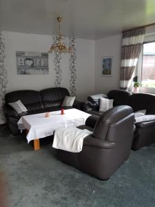 a living room with a couch and a table and chairs at Ferienhaus Leuchtturm in Geestland