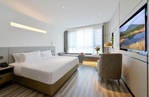 a bedroom with a bed and a large window at Mehood Lestie, Tianshui South Station Shengda Plaza in Tianshui